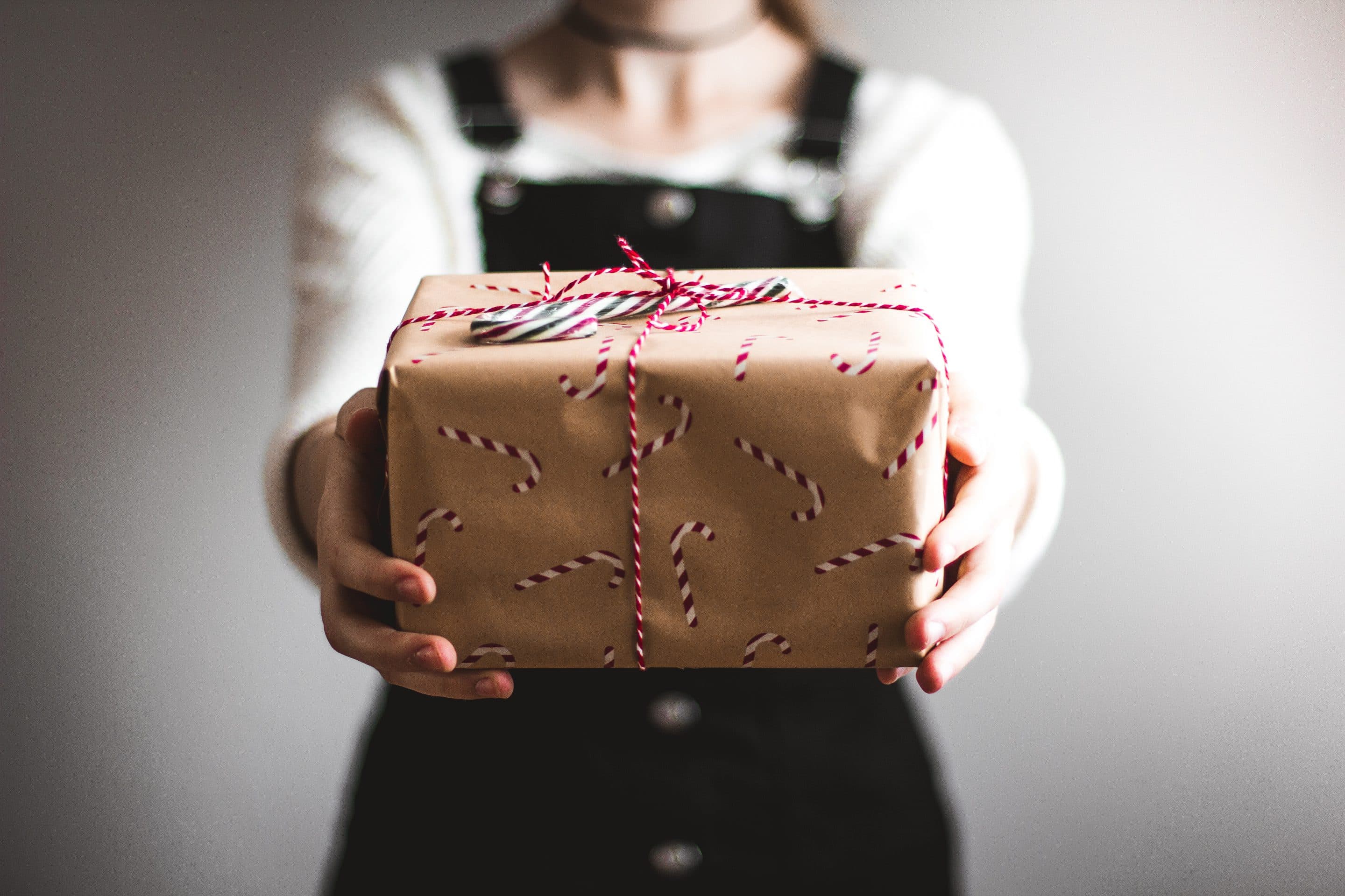 image of person holding out a wrapped gift from unsplash.com